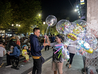 A man buys a ballons from a street vendor at Malioboro Street during holiday for the end of the year in Yogyakarta, Indonesia on December 30...