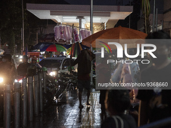 A cotton candy seller walks on pedestrian at the the Kota Tua Jakarta (Jakarta Old Town) tourism area during the holiday season, in Jakarta...