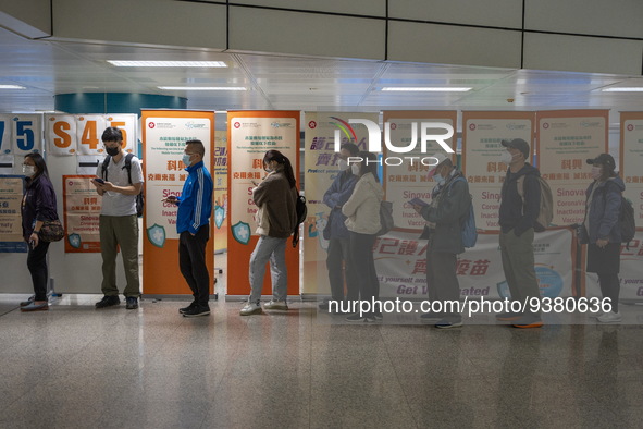 People lining up next to signs for the Sinovac CoronaVac Inactivated Vaccine by China Biotechnology company, Sinovac Biotech Ltd.,at a Covid...