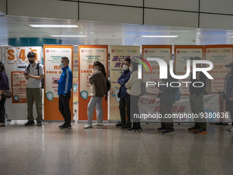 People lining up next to signs for the Sinovac CoronaVac Inactivated Vaccine by China Biotechnology company, Sinovac Biotech Ltd.,at a Covid...