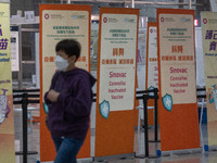 A women walks pass signs for the Sinovac CoronaVac Inactivated Vaccine by China Biotechnology company, Sinovac Biotech Ltd.,at a Covid-19 va...