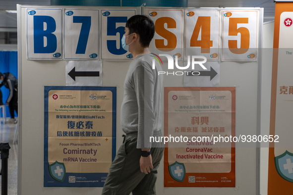 A man walks pass a sign for the Sinovac CoronaVac Inactivated Vaccine by China Biotechnology company, Sinovac Biotech Ltd. and a sign for th...