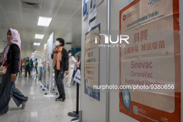 People walks pass a sign for the Sinovac CoronaVac Inactivated Vaccine by China Biotechnology company, Sinovac Biotech Ltd. at a Covid-19 va...