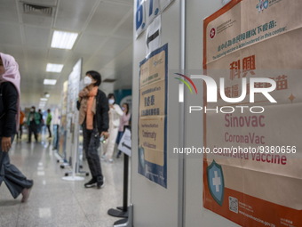 People walks pass a sign for the Sinovac CoronaVac Inactivated Vaccine by China Biotechnology company, Sinovac Biotech Ltd. at a Covid-19 va...