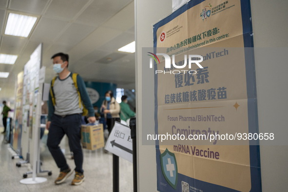 People walks pass a sign for the Comirnaty mRNA Vaccine by German biotechnology company BioNTech SE. at a Covid-19 vaccination station insid...