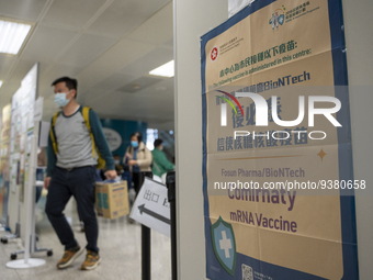 People walks pass a sign for the Comirnaty mRNA Vaccine by German biotechnology company BioNTech SE. at a Covid-19 vaccination station insid...