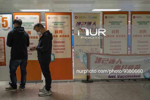 People lining up next to signs for the Sinovac CoronaVac Inactivated Vaccine by China Biotechnology company, Sinovac Biotech Ltd.,at a Covid...