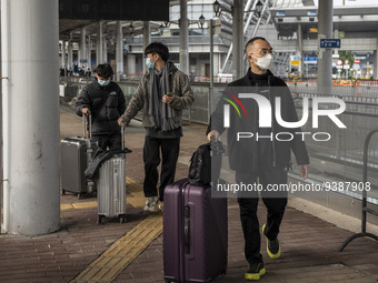 Travelers from China wearing face mask with luggages arrived in Shenzhen Bay Port on January 4, 2023 in Hong Kong, China. According to Local...