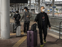 Travelers from China wearing face mask with luggages arrived in Shenzhen Bay Port on January 4, 2023 in Hong Kong, China. According to Local...