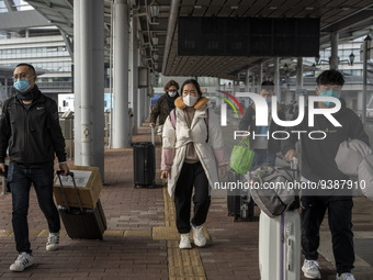 Travelers from China wearing face mask with luggages arrived in Shenzhen Bay Port on January 4, 2023 in Hong Kong, China. According to Local...