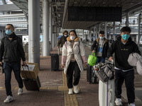 Travelers from China wearing face mask with luggages arrived in Shenzhen Bay Port on January 4, 2023 in Hong Kong, China. According to Local...