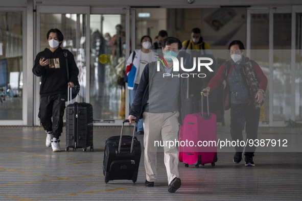 Travelers from China wearing face mask with luggages arrived in Shenzhen Bay Port on January 4, 2023 in Hong Kong, China. According to Local...