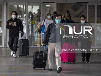 Travelers from China wearing face mask with luggages arrived in Shenzhen Bay Port on January 4, 2023 in Hong Kong, China. According to Local...