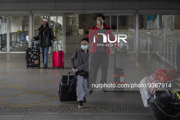 Travelers from China wearing face mask with luggages arrived in Shenzhen Bay Port on January 4, 2023 in Hong Kong, China. According to Local...