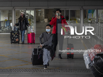 Travelers from China wearing face mask with luggages arrived in Shenzhen Bay Port on January 4, 2023 in Hong Kong, China. According to Local...