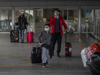 Travelers from China wearing face mask with luggages arrived in Shenzhen Bay Port on January 4, 2023 in Hong Kong, China. According to Local...