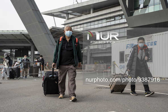 Travelers from China wearing face mask with luggages arrived in Shenzhen Bay Port on January 4, 2023 in Hong Kong, China. According to Local...