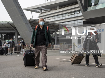 Travelers from China wearing face mask with luggages arrived in Shenzhen Bay Port on January 4, 2023 in Hong Kong, China. According to Local...