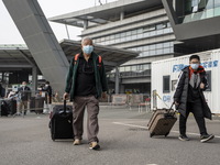 Travelers from China wearing face mask with luggages arrived in Shenzhen Bay Port on January 4, 2023 in Hong Kong, China. According to Local...