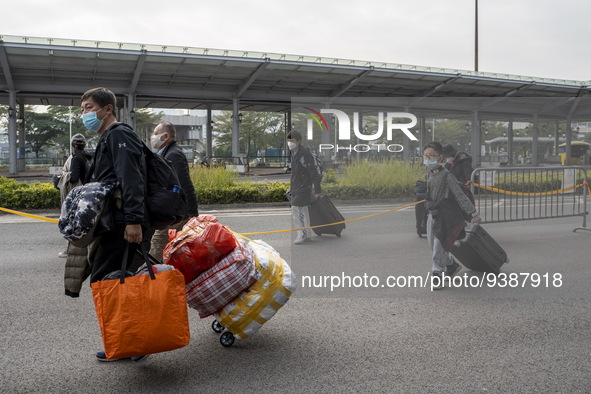 Travelers from China wearing face mask with luggages arrived in Shenzhen Bay Port on January 4, 2023 in Hong Kong, China. According to Local...