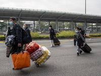 Travelers from China wearing face mask with luggages arrived in Shenzhen Bay Port on January 4, 2023 in Hong Kong, China. According to Local...