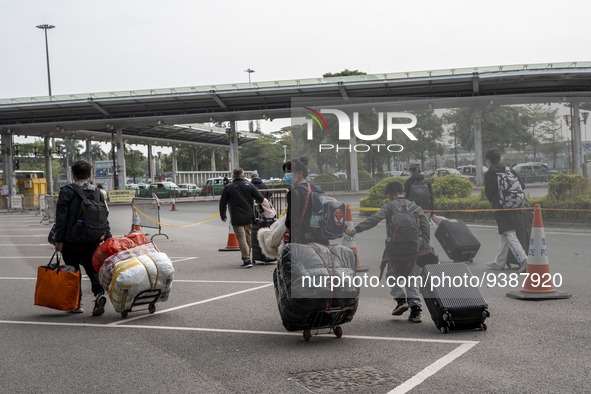 Travelers from China wearing face mask with luggages arrived in Shenzhen Bay Port on January 4, 2023 in Hong Kong, China. According to Local...