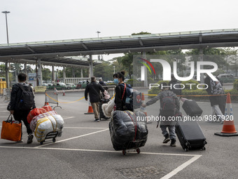 Travelers from China wearing face mask with luggages arrived in Shenzhen Bay Port on January 4, 2023 in Hong Kong, China. According to Local...