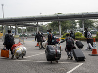 Travelers from China wearing face mask with luggages arrived in Shenzhen Bay Port on January 4, 2023 in Hong Kong, China. According to Local...