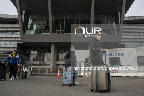 Travelers from China wearing face mask with luggages arrived in Shenzhen Bay Port on January 4, 2023 in Hong Kong, China. According to Local...