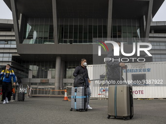 Travelers from China wearing face mask with luggages arrived in Shenzhen Bay Port on January 4, 2023 in Hong Kong, China. According to Local...