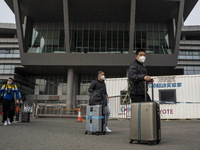 Travelers from China wearing face mask with luggages arrived in Shenzhen Bay Port on January 4, 2023 in Hong Kong, China. According to Local...