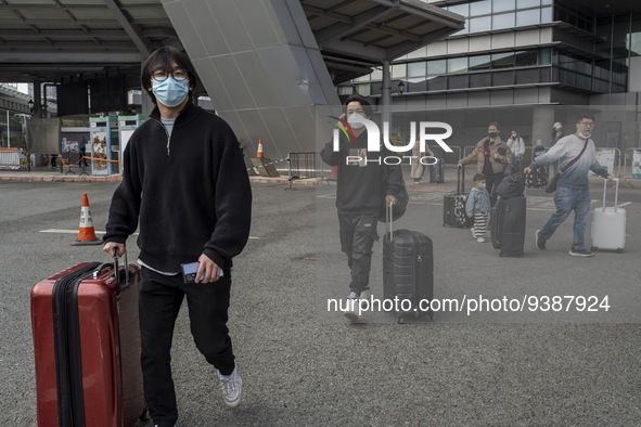 Travelers from China wearing face mask with luggages arrived in Shenzhen Bay Port on January 4, 2023 in Hong Kong, China. According to Local...