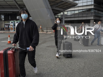 Travelers from China wearing face mask with luggages arrived in Shenzhen Bay Port on January 4, 2023 in Hong Kong, China. According to Local...