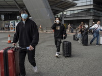 Travelers from China wearing face mask with luggages arrived in Shenzhen Bay Port on January 4, 2023 in Hong Kong, China. According to Local...