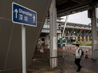 A man walks pass sign pointing to Shenzhen in Shenzhen Bay Port on January 4, 2023 in Hong Kong, China. According to Local Media Reports,  t...