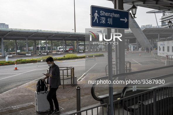 A man walk pass a sign pointing to Shenzhen in Shenzhen Bay Port on January 4, 2023 in Hong Kong, China. According to Local Media Reports,...