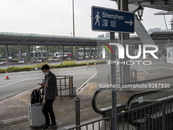 A man walk pass a sign pointing to Shenzhen in Shenzhen Bay Port on January 4, 2023 in Hong Kong, China. According to Local Media Reports,...