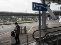 A man walk pass a sign pointing to Shenzhen in Shenzhen Bay Port on January 4, 2023 in Hong Kong, China. According to Local Media Reports,...