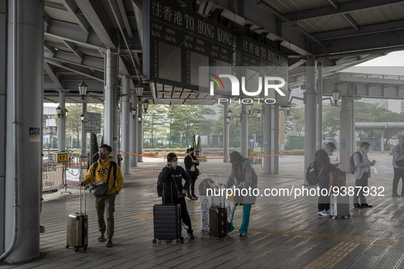 Travelers from China wearing face mask with luggages arrived in Shenzhen Bay Port on January 4, 2023 in Hong Kong, China. According to Local...