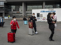 Travelers from China wearing face mask with luggages arrived in Shenzhen Bay Port on January 4, 2023 in Hong Kong, China. According to Local...