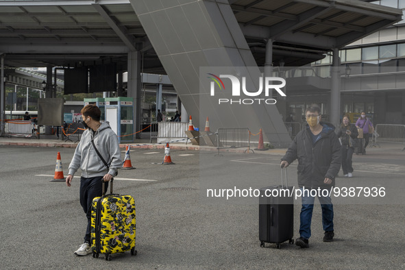 Travelers from China wearing face mask with luggages arrived in Shenzhen Bay Port on January 4, 2023 in Hong Kong, China. According to Local...