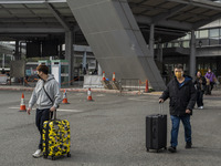 Travelers from China wearing face mask with luggages arrived in Shenzhen Bay Port on January 4, 2023 in Hong Kong, China. According to Local...