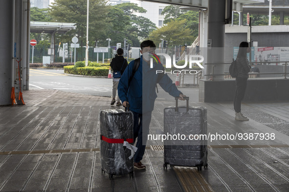 Travelers from China wearing face mask with luggages arrived in Shenzhen Bay Port on January 4, 2023 in Hong Kong, China. According to Local...