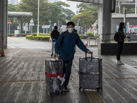 Travelers from China wearing face mask with luggages arrived in Shenzhen Bay Port on January 4, 2023 in Hong Kong, China. According to Local...