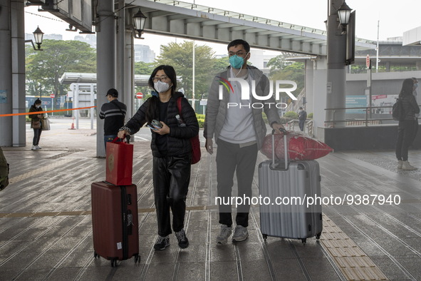 Travelers from China wearing face mask with luggages arrived in Shenzhen Bay Port on January 4, 2023 in Hong Kong, China. According to Local...