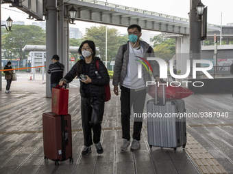 Travelers from China wearing face mask with luggages arrived in Shenzhen Bay Port on January 4, 2023 in Hong Kong, China. According to Local...