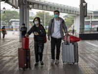 Travelers from China wearing face mask with luggages arrived in Shenzhen Bay Port on January 4, 2023 in Hong Kong, China. According to Local...