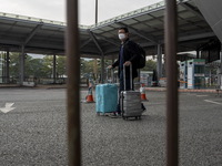 Travelers from China wearing face mask with luggages arrived in Shenzhen Bay Port on January 4, 2023 in Hong Kong, China. According to Local...