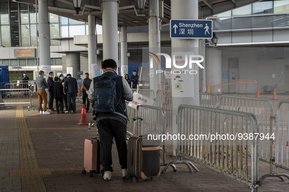 A man stands next to a sign pointing to Shenzhen in Shenzhen Bay Port on January 4, 2023 in Hong Kong, China. According to Local Media Repor...