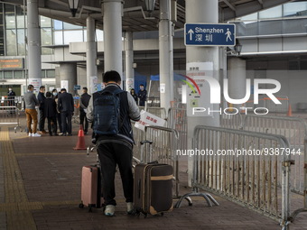 A man stands next to a sign pointing to Shenzhen in Shenzhen Bay Port on January 4, 2023 in Hong Kong, China. According to Local Media Repor...